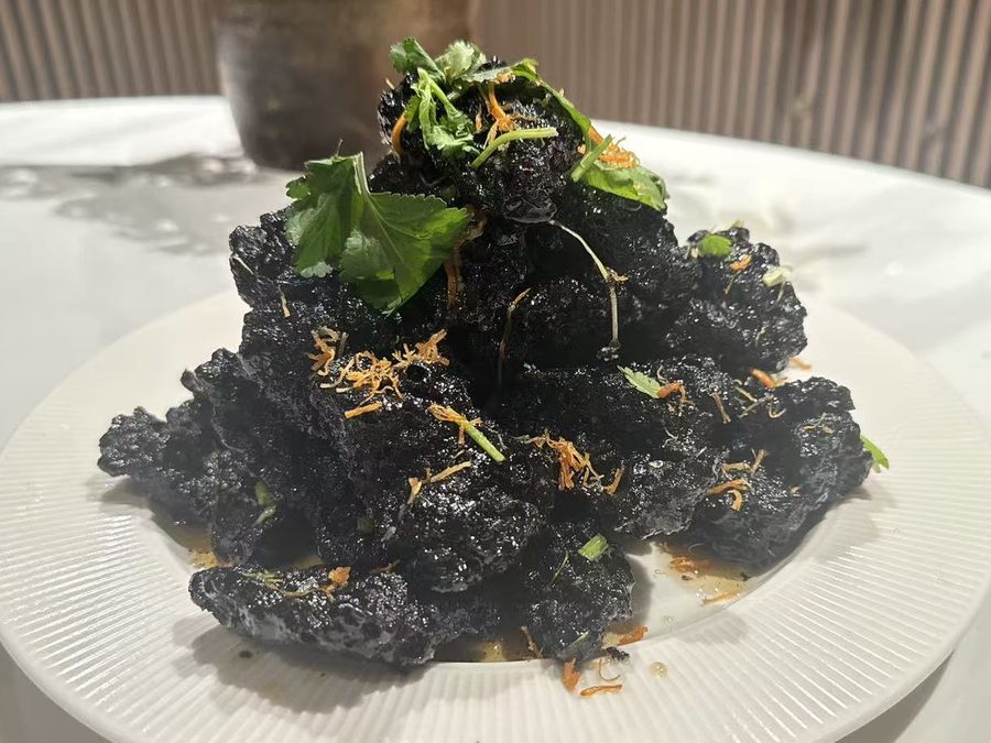 Black Gold crispy pork glazed in squid ink sweet and sour sauce, topped with coriander and dried scallop