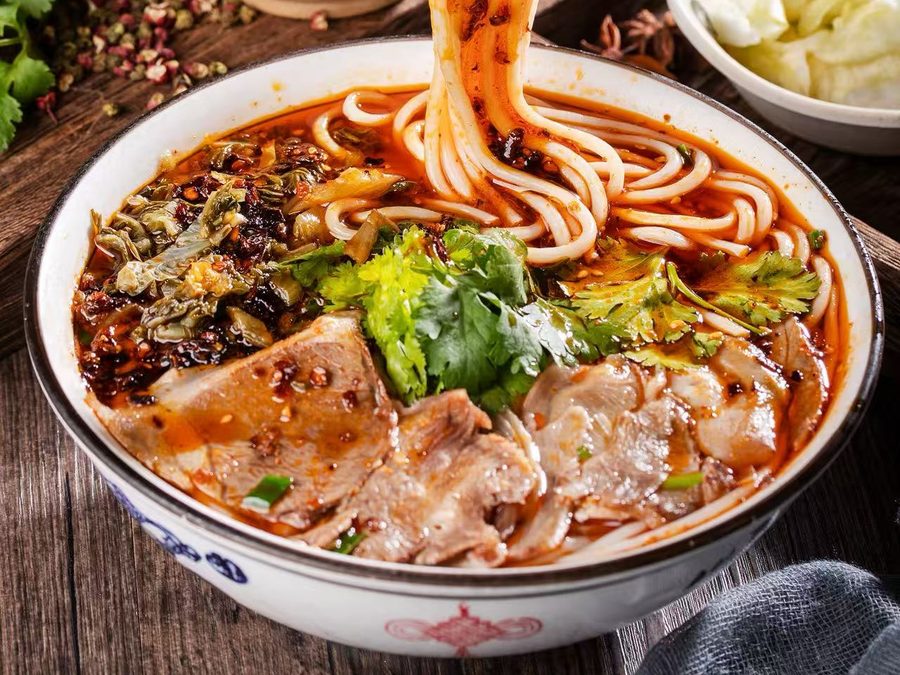 Lamb rice noodle soup in chilli broth with sliced lamb, pickled greens and coriander