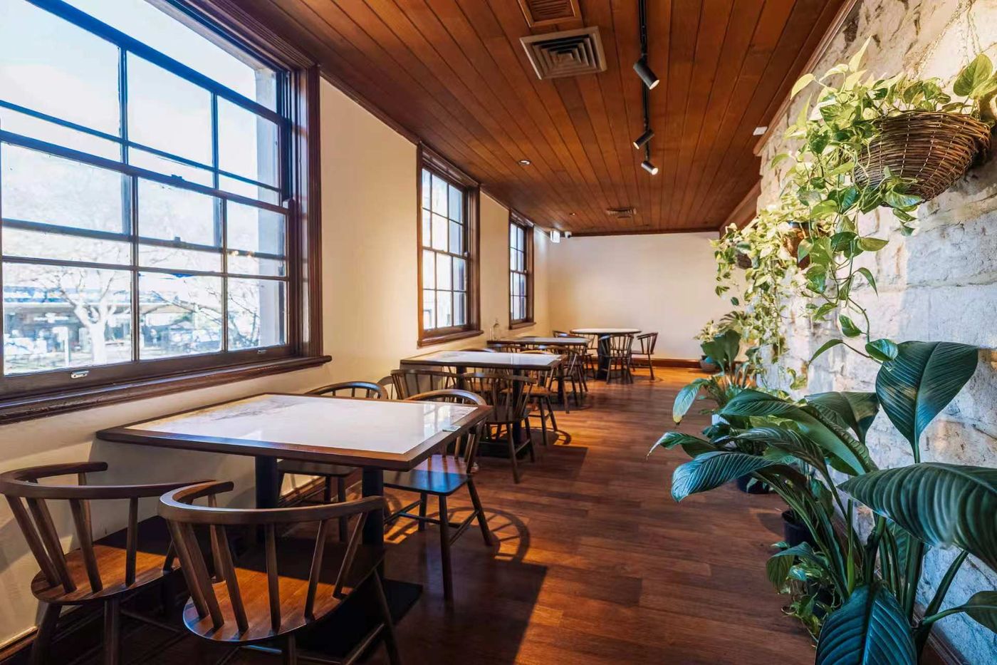 Marble-topped tables and timber chairs beside the tall windows at Golden Tree Bistro