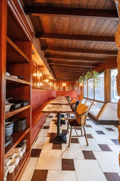 Leather banquette seating along a checkerboard-tiled room