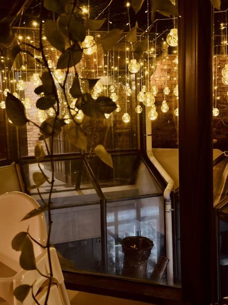 Strings of glass bulb lights glowing over the courtyard glass roof